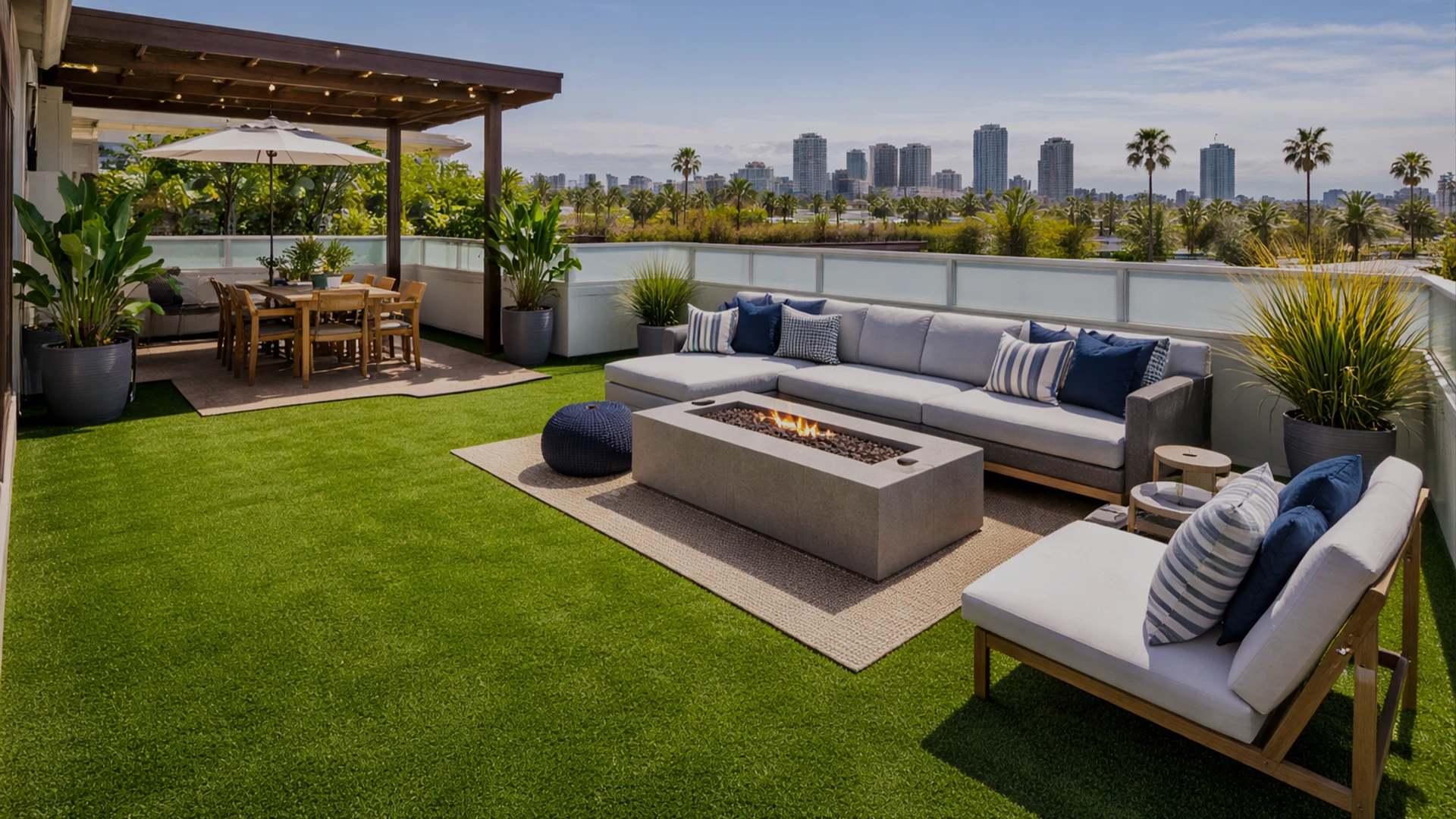 Rooftop patio with seating, fire pit, dining area, and city skyline in the background
