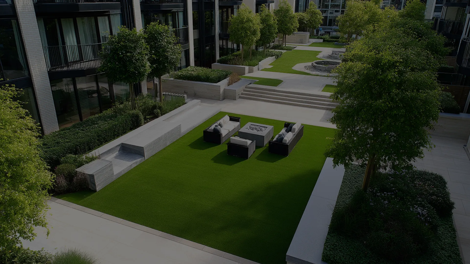 A landscaped courtyard with grass, seating areas, and trees