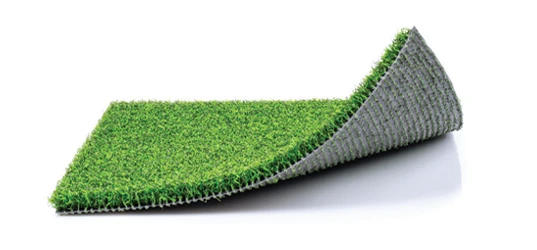 Artificial grass mat rolled partially over itself on a white background