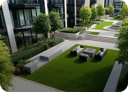 Outdoor area with grass, seating, plants, and pathways near modern buildings