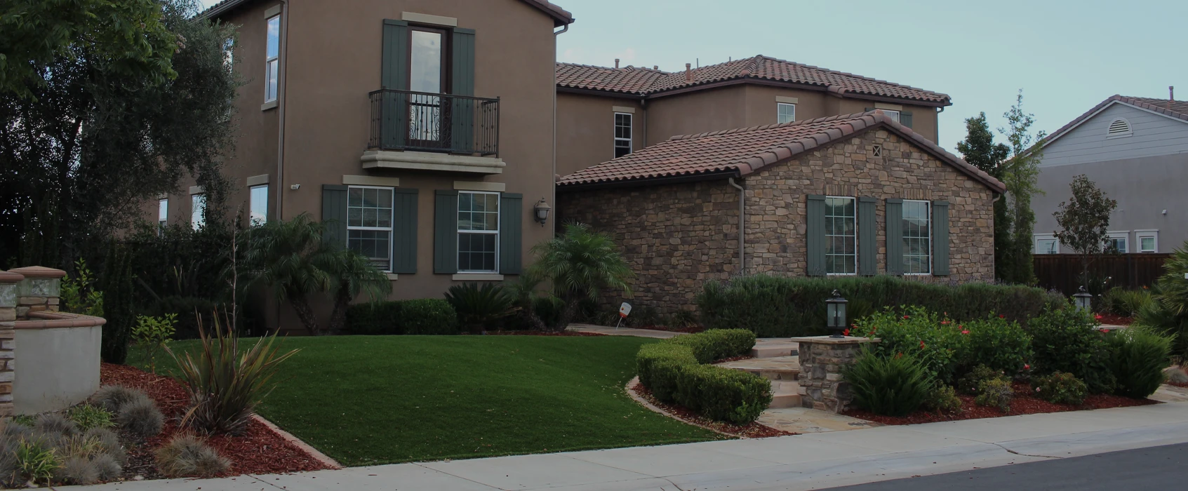 Two-story house with a stone façade and landscaped front yard