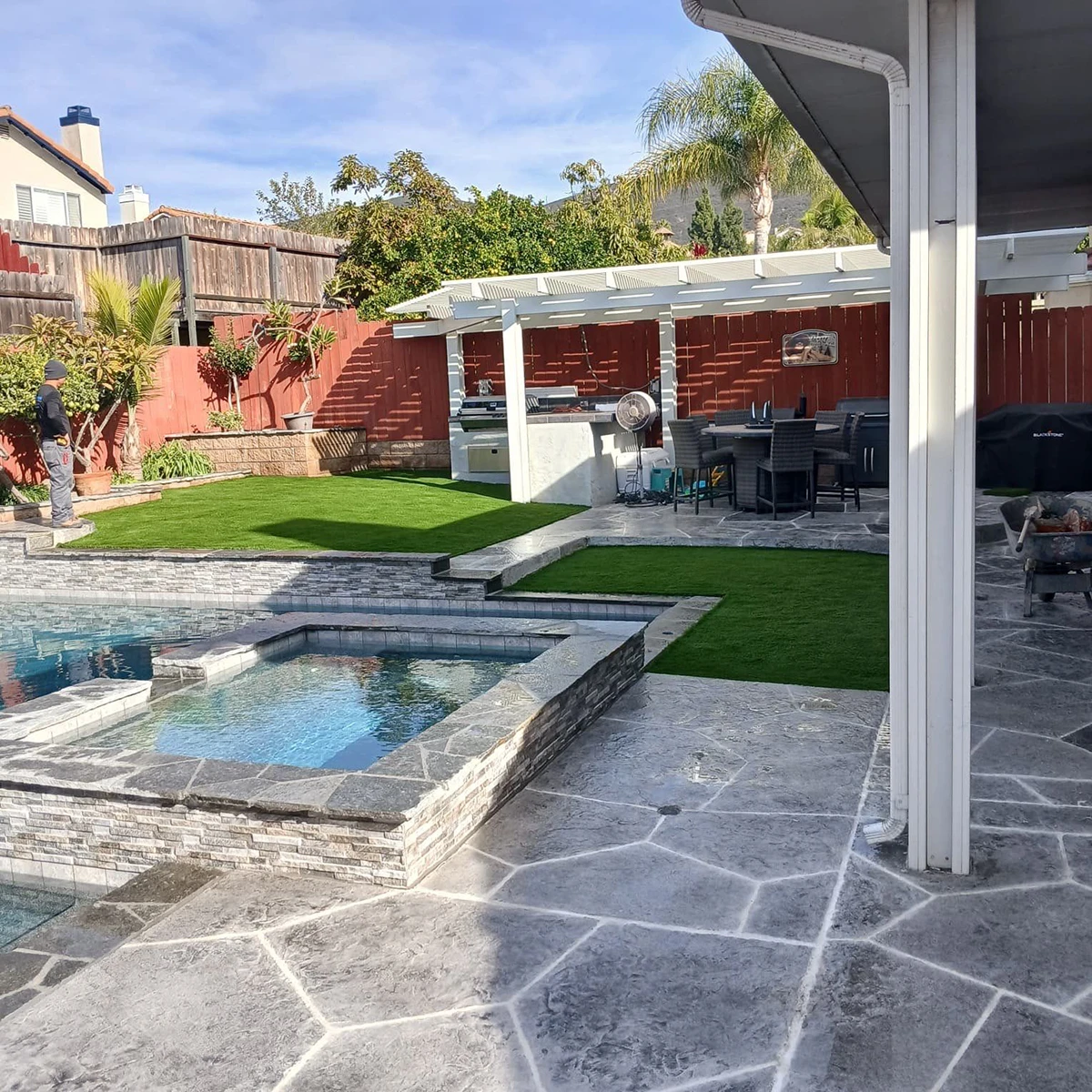 Backyard view with a pool, spa, grassy area, covered patio, and outdoor seating