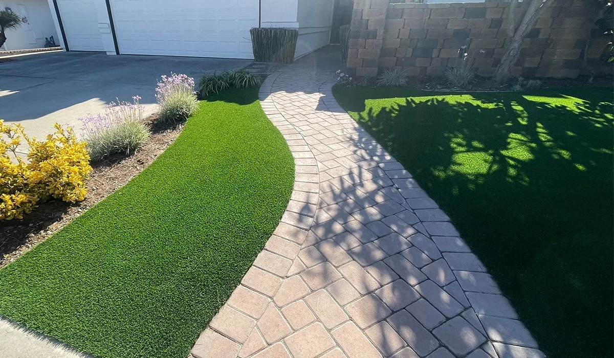 A curved stone pathway bordered by green grass and shrubs