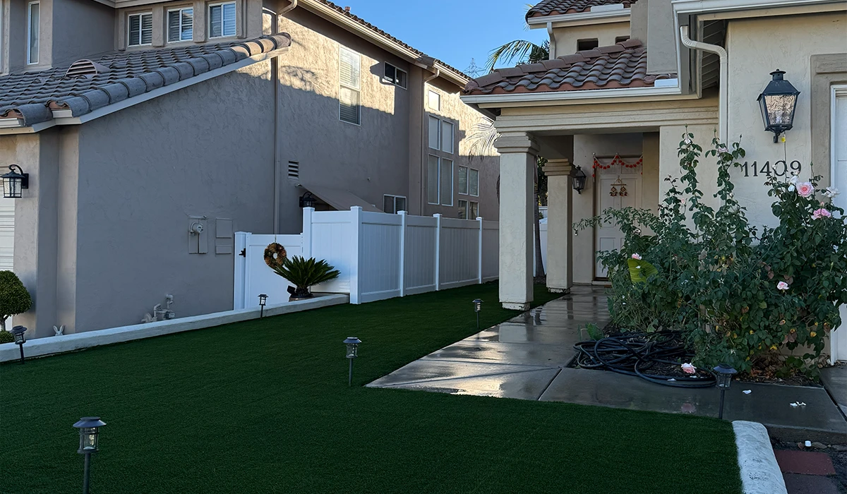 House exterior with a front yard featuring artificial grass and decorative plants