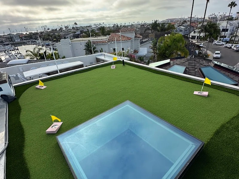 Rooftop view featuring a green area, a small pool, and yellow flags marking spots