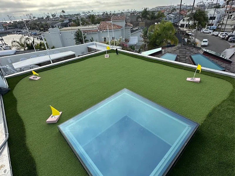 Rooftop area with artificial grass, a small pool, and yellow flags marking positions